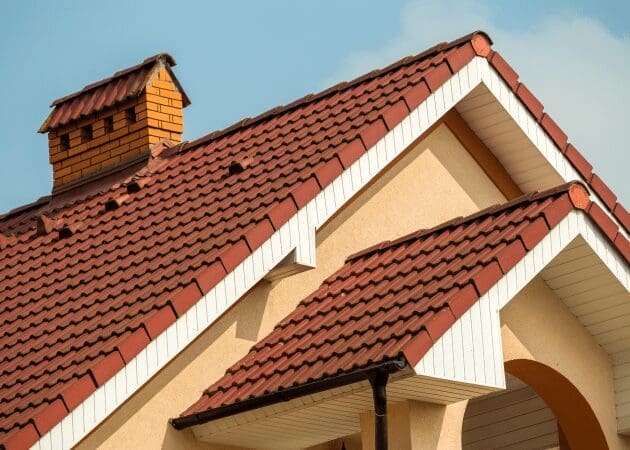 House with red tile roof and chimney.