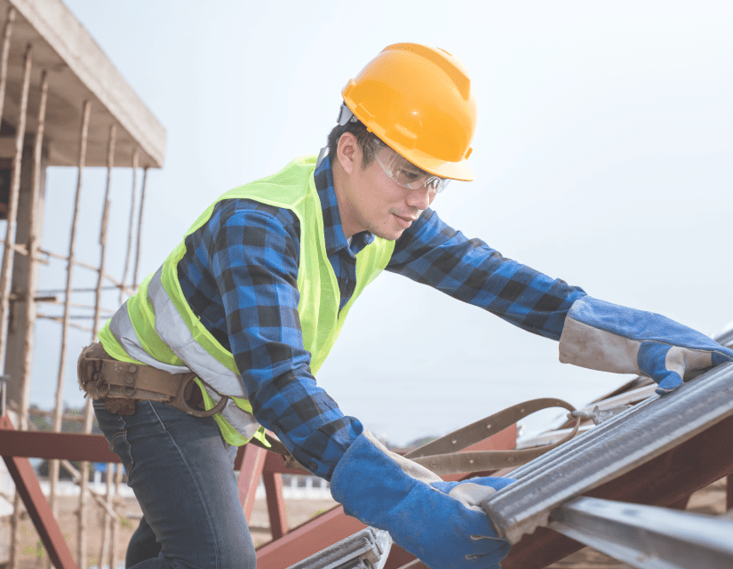 Construction worker installing roof panels.