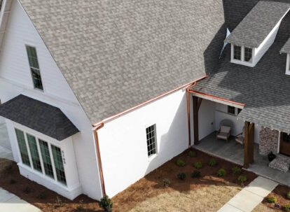 White farmhouse with copper gutters.